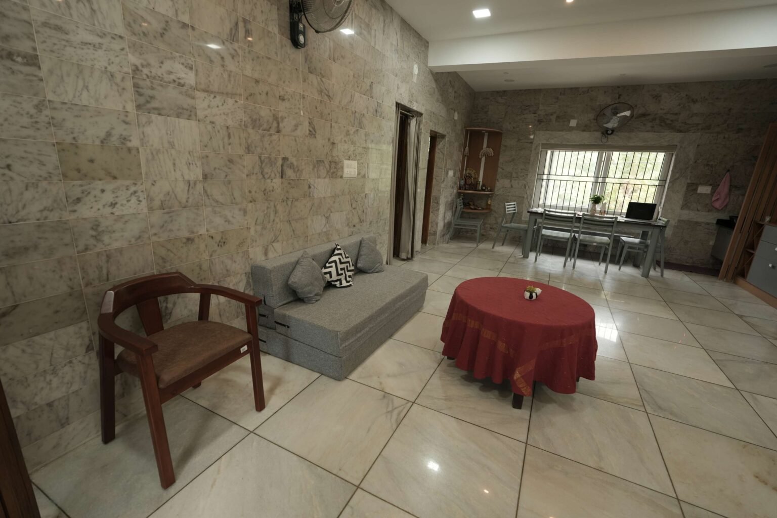 A living area with a sofa-cum-bed, armchair and table