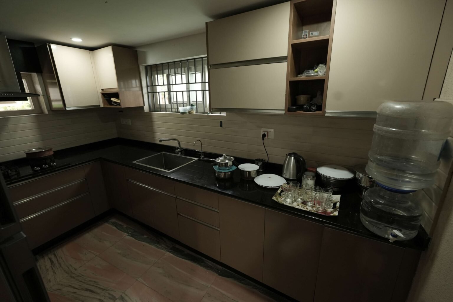A fitted kitchen with stovetop, sink and cabinets
