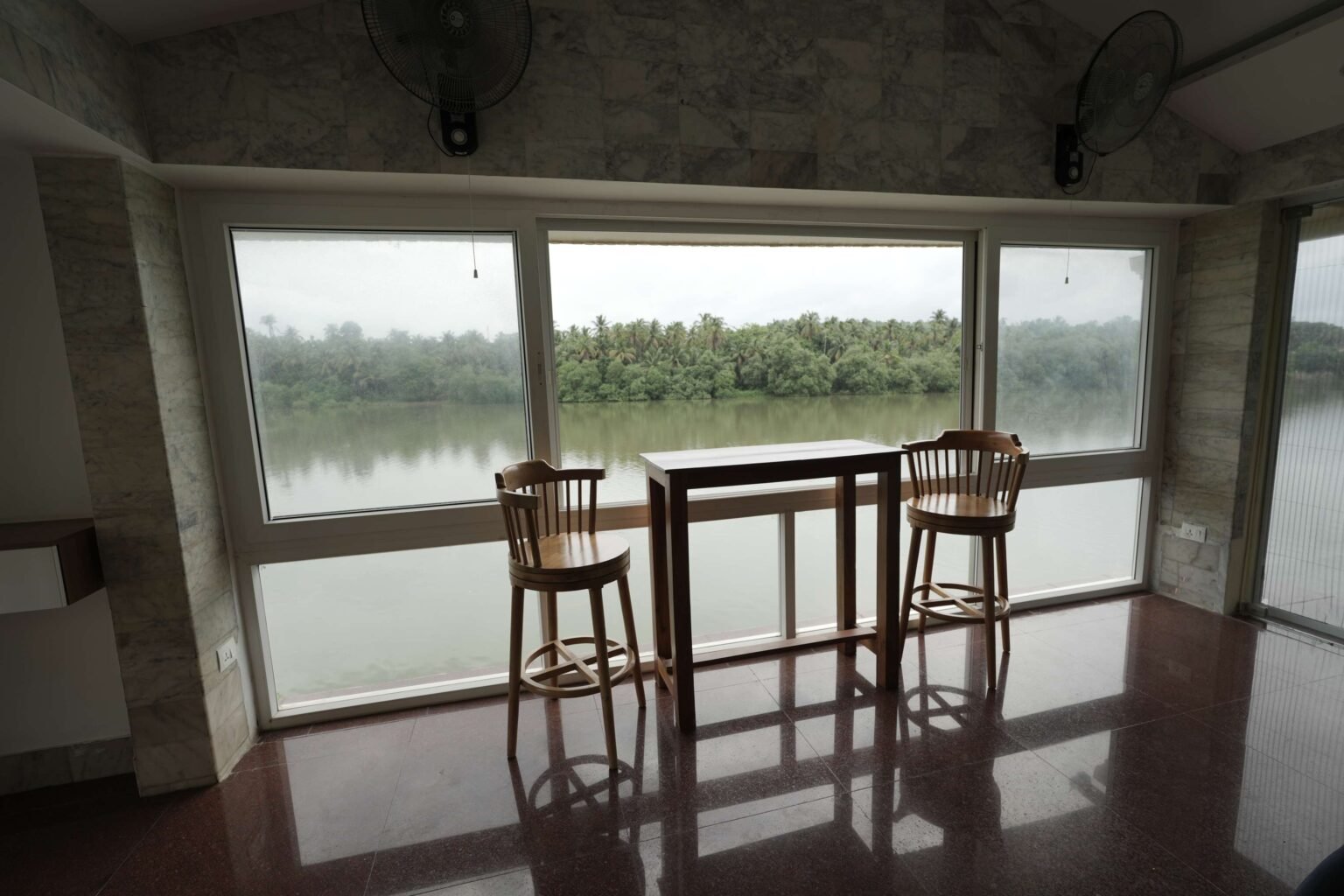 Bar stools at the glass wall, with the river beyond