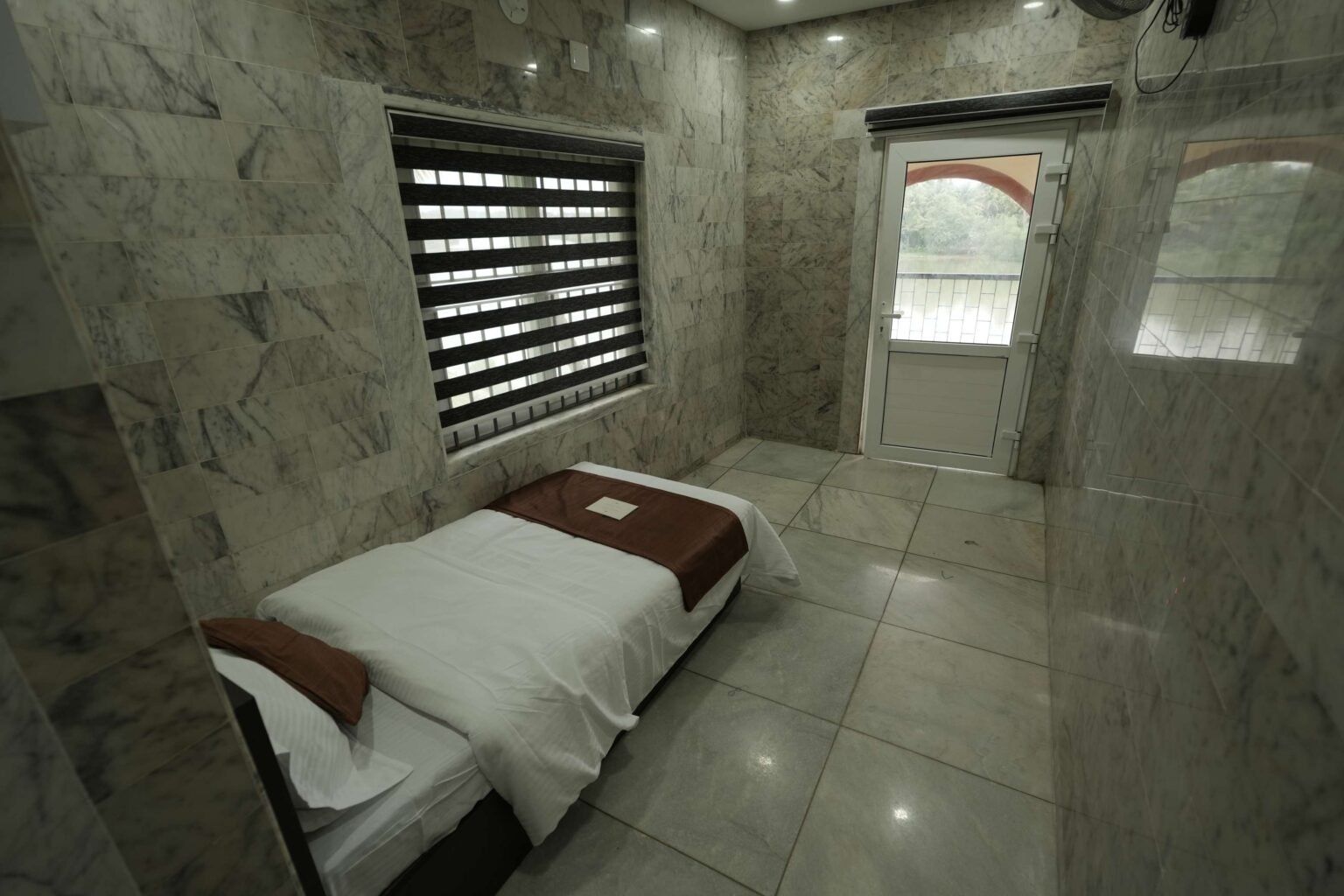The third bedroom, with a bed beside a shuttered window