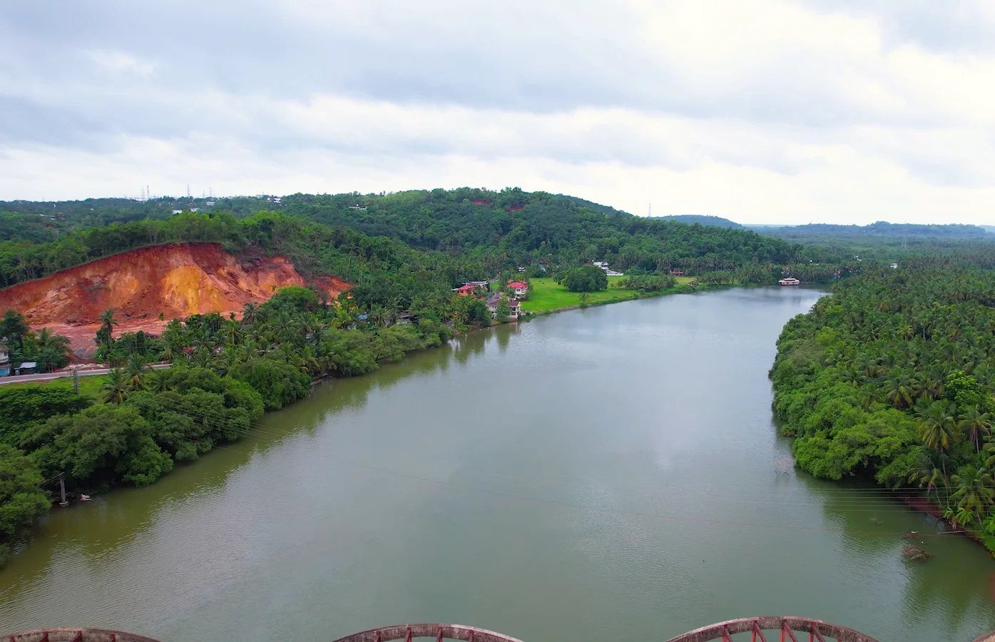 The Kuppam River winding between coconut palms and green hills, seen from above